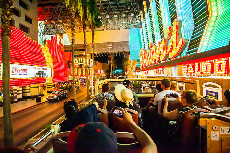 The Las Vegas Big Bus driving by Binion's Casino at the Fremont Street Experience during the optional night tour.