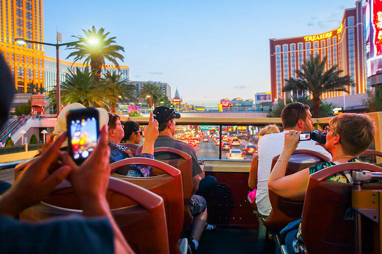 Tourists taking photos just after sunset on the Big Bus Las Vegas Hop-On Hop-Off tour.